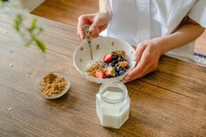 A vibrant homemade yogurt bowl with strawberries, blueberries, and crushed nuts, perfect for a healthy breakfast.
