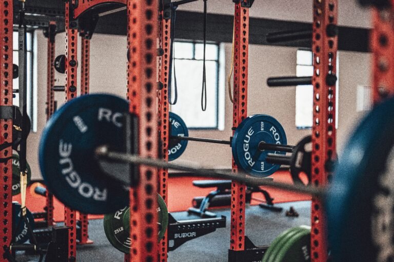 Close-up view of gym equipment with barbells and weight plates, perfect for strength training enthusiasts.